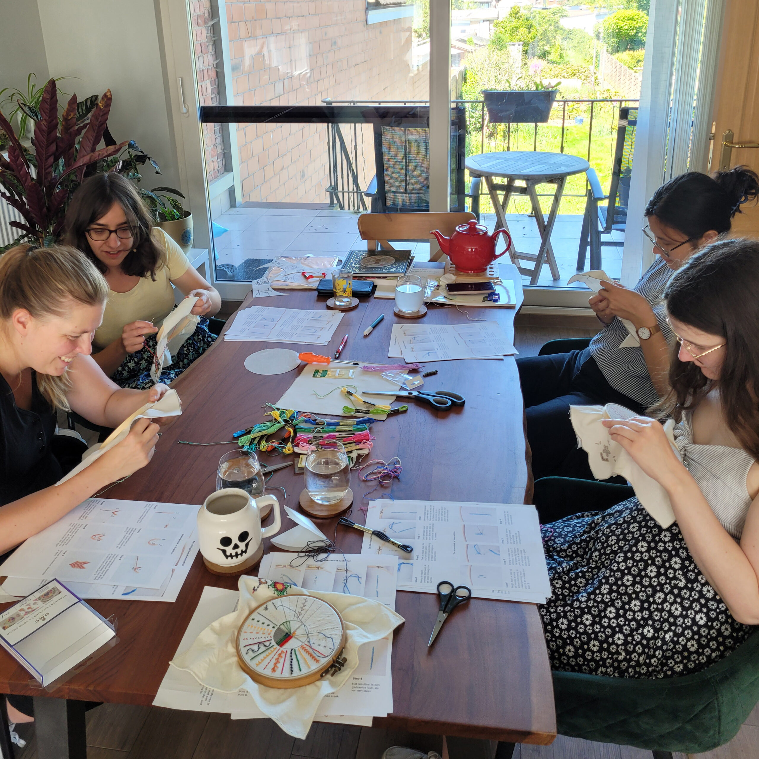 Workshop borduren aan een tafel met 4 dames.